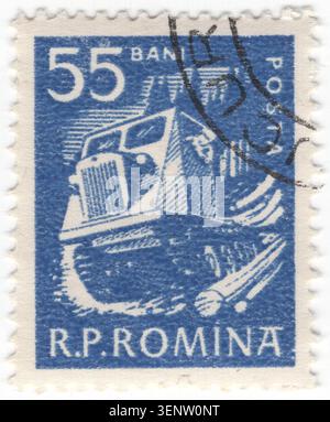 ROUMANIE - 1960 juin : timbre-poste bleu interdit de 55 représentant un tracteur à chenilles lourd (débardeur de bois) transportant des grumes fraîchement coupées de la forêt sur un terrain accidenté. Le véhicule est doté d'une calandre proéminente et d'une cabine de conduite fermée, mettant en valeur les technologies industrielles utilisées pour extraire les ressources naturelles. Cette image reflète l'accent mis sur la récolte du bois, l'industrialisation, la gestion des ressources, la mécanisation de la foresterie et l'exploitation du bois pendant la période d'après-guerre, célébrant la production de matières premières dans l'économie planifiée de la République populaire de Roumanie Banque D'Images
