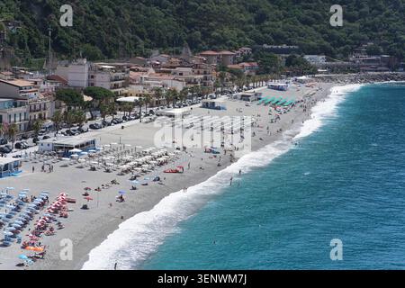 Vue aérienne de Scilla Beach bondée avec des parasols, ville et colline verte à Scilla, Calabre, Italie par jour ensoleillé. Banque D'Images
