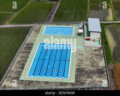 Vue aérienne de deux piscines sur un site rural. Une piscine dispose de couloirs pour les nageurs. L'autre est plus petit et non doublé. Un petit bâtiment se trouve à côté des piscines. Sur Banque D'Images