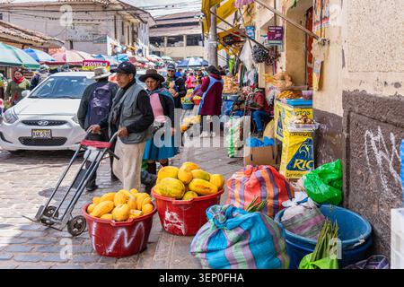 Cusco, Pérou - 23 mars 2025 : marché de rue animé avec vendeurs de fruits et piétons à Cusco Banque D'Images