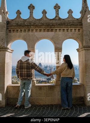Budapest, en Hongrie, offre une vue imprenable depuis le Bastion des pêcheurs tandis qu'un couple se tient la main et admire la ligne d'horizon. Banque D'Images