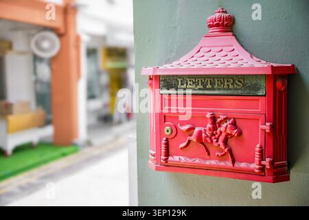 Gros plan de la boîte aux lettres décorative rouge avec le signe de lettres monté sur le mur avec une faible profondeur de champ Banque D'Images
