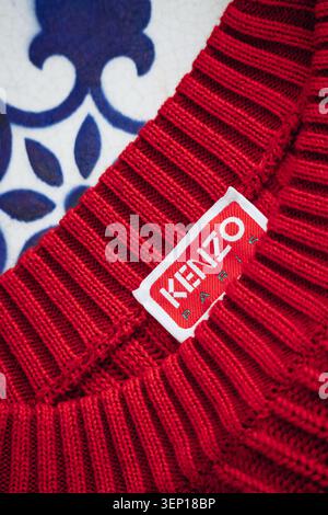 Nice, France - 1er mars 2026 : gros plan d'un vêtement tricoté rouge Kenzo Paris avec l'étiquette tissée de la marque, la construction du col côtelé et le t Banque D'Images