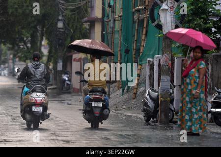 Siliguri, Bengale occidental, Inde. 13 juin 2026. Les gens montent deux roues avec un parapluie pendant la pluie à Siliguri. (Crédit image : © Diptendu Dutta/ZUMA Press Wire) USAGE ÉDITORIAL SEULEMENT ! Non destiné à UN USAGE commercial ! Banque D'Images