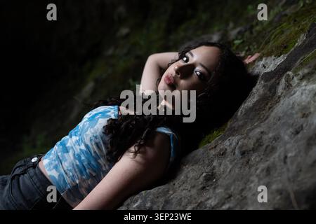 Jeune femme se relaxant sur un rocher dans la nature Banque D'Images