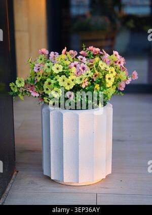 Gros plan de fleurs artificielles dans un pot de fleurs décoratif. Photo de haute qualité Banque D'Images