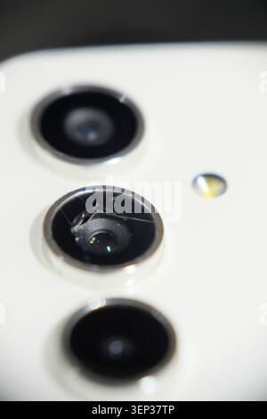 Photo macro d'un objectif d'appareil photo de smartphone fissuré et cassé sur un fond blanc avec mise au point sélective Banque D'Images
