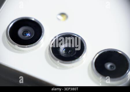 Photo macro d'un objectif d'appareil photo de smartphone fissuré et cassé sur un fond blanc avec mise au point sélective Banque D'Images