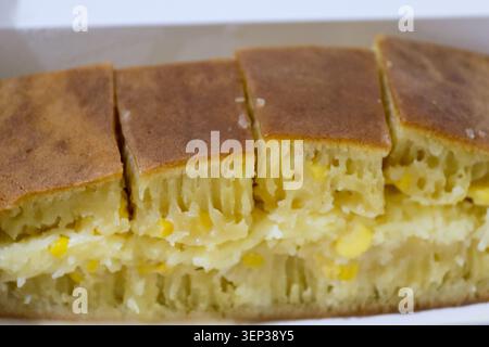 Délicieux fromage manis martabak et garniture de maïs sucré, dessert traditionnel indonésien de rue sucré tranché sur une boîte à emporter Banque D'Images