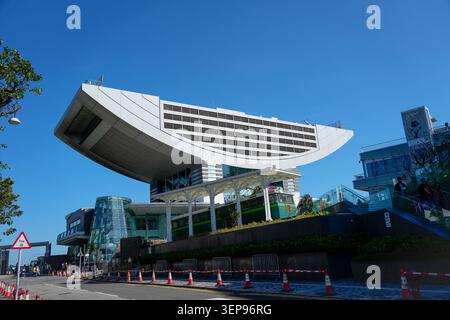 Un bâtiment moderne se distingue par sa forme unique dans une zone urbaine animée Victoria Peak. Chine, Hong Kong. 19 janvier 2024. Banque D'Images