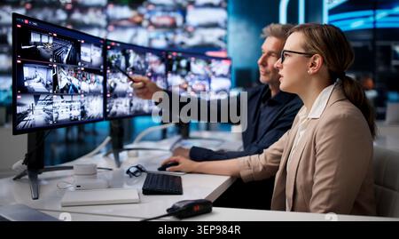 L'agent de sécurité surveille plusieurs écrans de vidéosurveillance pour surveiller la sécurité du bâtiment. Banque D'Images