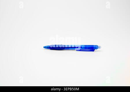 Stylo à bille bleu doté d'un corps translucide et d'une poignée ergonomique, reposant horizontalement sur un fond blanc propre, offrant un espace suffisant pour le texte O. Banque D'Images