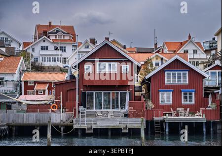 Charmant cottage rouge avec garniture blanche et toit carrelé dans un village calme en bord de mer Banque D'Images