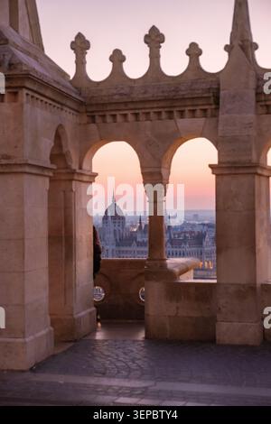 Budapest, Hongrie offre une vue imprenable sur le coucher du soleil depuis le Bastion des pêcheurs, mettant en valeur l'architecture complexe et le bâtiment emblématique du Parlement. Banque D'Images