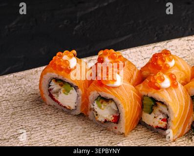Une assiette contient plusieurs rouleaux de sushi disposés soigneusement. Les couleurs vives montrent les ingrédients de chaque rouleau. Banque D'Images