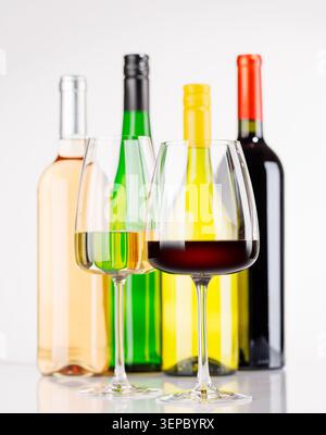Différentes bouteilles de vin et verres sur fond blanc, composition de vin élégante Banque D'Images