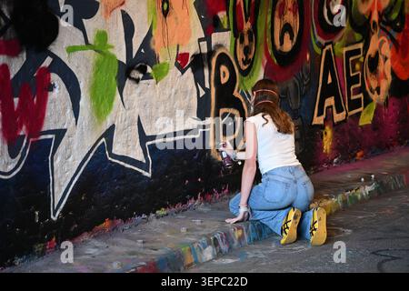 Jeune femme artiste graffiti au travail à Leake Street Arches - Londres Banque D'Images