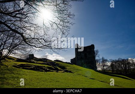 Un château en ruines se trouve au sommet d'une colline herbeuse par une journée ensoleillée d'hiver, Peveril Castle, Castleton, Peak District, Derbyshire. Banque D'Images