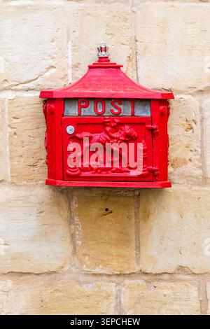 Boîte aux lettres vintage Red Post montée sur un mur de pierre avec relief décoratif de cheval Banque D'Images