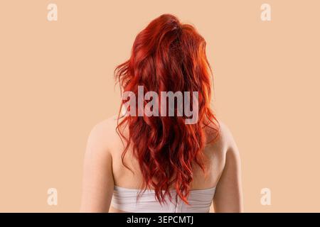 Femme avec de longs cheveux roux ondulés de derrière, concept de l'industrie des soins capillaires et de la beauté, texture naturelle des cheveux Banque D'Images