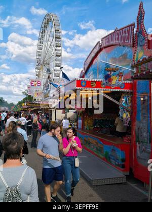Pforzheim Allemagne - 14 juin 2026 Mess Une scène de foire en plein air animée avec une grande roue de grande taille blanche dominant un ciel bleu avec des nuages dispersés Banque D'Images