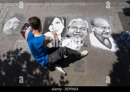 Artiste travaillant sur Amy Winehouse, Ghandi, John Lennon et Nelson Mandela dessins à la craie sur le plancher de la chaussée à Camden Market Londres Banque D'Images