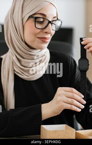 Femme dans Hijab Unboxing Smartwatch Banque D'Images
