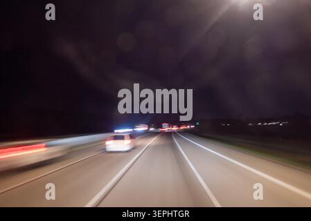 Dark night highway traffic light trails long exposure view from moving Banque D'Images