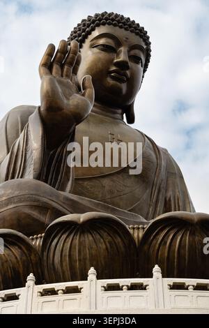 Gros plan de la statue de bronze de Tian Tan Buddha (Big Buddha) à Ngong Ping, montrant la main droite levée, le visage serein et l'esprit de robe finement sculpté Banque D'Images