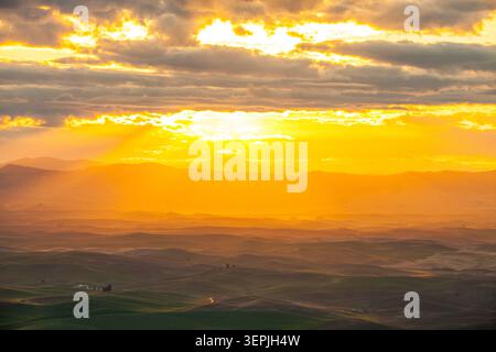 Des rayons de soleil dorés surplombent les collines verdoyantes Banque D'Images