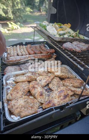 Griller de la viande, des saucisses, des légumes sur un gril à gaz. Banque D'Images