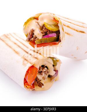 Deux wraps remplis de viande, de légumes et de sauce sont assis côte à côte sur un fond blanc. Ils montrent les ingrédients frais à l'intérieur et les marques grillées sur les wraps. Banque D'Images