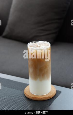 Un verre de café glacé avec du lait dans un salon confortable. Latte glacé Banque D'Images