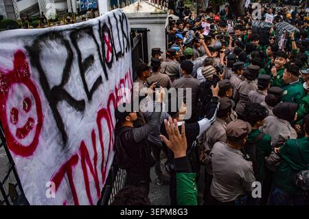Medan, Indonésie. 15 juin 2026. Les manifestants se rassemblent lors d'un rassemblement de masse tendu devant le bâtiment du Conseil législatif régional du Nord de Sumatra (DPRD Sumut) à Medan le 15 juin 2026, protestant contre les récentes politiques sociopolitiques. Tout en s’alignant sur les principales doléances nationales observées à Jakarta, la mobilisation de Medan a présenté un manifeste localisé en sept points exigeant que le gouvernement s’attaque immédiatement et accélère la distribution de l’aide aux victimes du cyclone tropical Senyar à travers Sumatra. Photo de Sutanta Aditya/ABACAPRESS.COM crédit : Abaca Press/Alamy Live News Banque D'Images