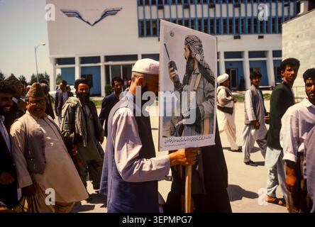 Les partisans du Front national islamique d'Afghanistan (NIFA) de Pir Sayyid Ahmad Gailani se rassemblent à l'aéroport de Kaboul avec des portraits de leur chef et d'un commandant moudjahidin, à Kaboul, en août 1992. Banque D'Images