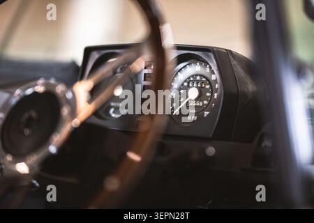 Vue rapprochée du tableau de bord d'une automobile rétro, mettant l'accent sur l'indicateur de vitesse et le compteur kilométrique analogiques Banque D'Images