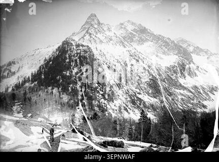Couvert de neige, le pic de la pique s'élève au-dessus des environs de Luchon en 1859, où Eugène Trutat enregistre un paysage hivernal montagneux avec des pentes, des zones boisées et un relief alpin élevé dans la région du Luchonnais. Banque D'Images