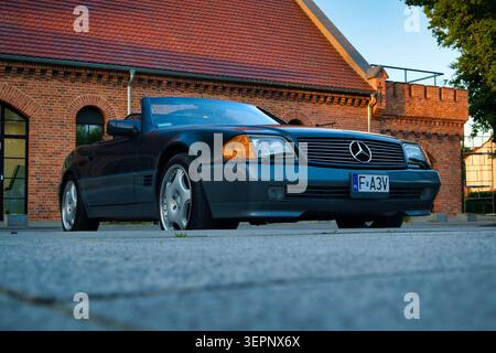 Mercedes 300SL Cabriolet classique garé devant le bâtiment historique en briques au coucher du soleil Banque D'Images