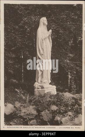 Une statue de la Vierge Marie se dresse dans le parc du Séminaire de Saulcy-sur-Meurthe dans les Vosges, au milieu d’un terrain paysager reflétant la pratique religieuse dévotionnelle et l’espace sacré extérieur de l’institution. Banque D'Images