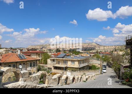 Cette image capture une vue panoramique de la Cappadoce, mettant en valeur l'architecture traditionnelle sur fond de formations rocheuses étonnantes et une belle Banque D'Images