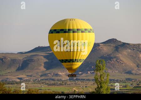 Une montgolfière dynamique flotte gracieusement au-dessus des magnifiques paysages de Cappadoce, en Turquie. Banque D'Images