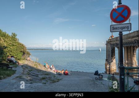Friedrichshafen Sommerabend am Bodensee in Friedrichshafen Friedrichshafen, Baden-Württemberg, Deutschland Menschen genießen an einem warmen Sommerabend den Seezugang nahe der Uferpromenade in Friedrichshafen. IM Hintergrund sind Segelboote auf dem Bodensee und die Alpenkette am gegenüberliegenden Ufer zu sehen. 15.06.2026. *** Friedrichshafen Copyright : xEibner-Pressefotox EP EER Banque D'Images