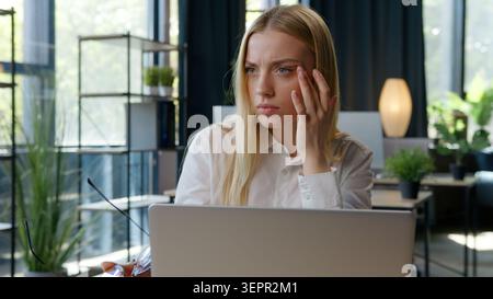 Fatigué femme d'affaires caucasienne avec ordinateur portable de travail de navigation prendre des lunettes pensant idée ressentant mal de tête femme d'affaires femme d'affaires travail Banque D'Images