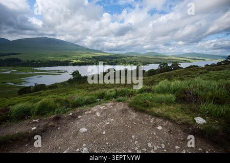 Loch Tulla et Highland montagnes vues d'un chemin de gravier sur la West Highland Way près de Bridge of Orchy, en Écosse. Banque D'Images