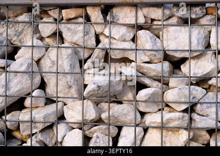 Texture en gros plan d'un mur de soutènement de gabion en pierre dans un treillis métallique. Concept : solutions d'ingénierie, design moderne, backgraund, textur Banque D'Images