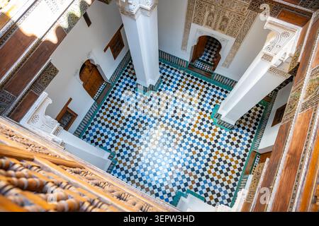 L'intérieur de la Madrasa Ben Youssef montre des chambres d'étudiants avec des carreaux colorés et un mobilier simple. Banque D'Images