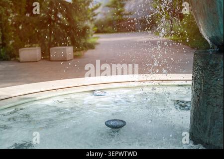 Fontaine du parc de la ville avec jets d'eau éclaboussant dans la lumière du soleil d'été. Design moderne Banque D'Images