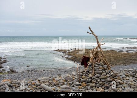 Driftwood Shelter et Stone Cairn sur Rocky Coast près de Hartland point, Devon Banque D'Images