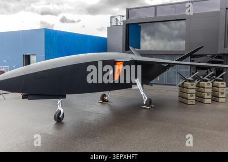 Vue de face du porte-missiles uav d'avion sans pilote avancé à l'extérieur de la chaussée mouillée ciel nuageux. Défense futuriste de surveillance de la technologie aérospatiale Banque D'Images