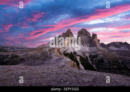 Tre Cime di Lavaredo sous les nuages colorés du lever du soleil dans les Dolomites après la première chute de neige. Les sommets calcaires emblématiques brillent dans la lumière matinale dans les Alpes italiennes Banque D'Images